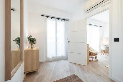 a white room with a door and a mirror at Grand T4 chic près du Port Balcon & Clim in Nice