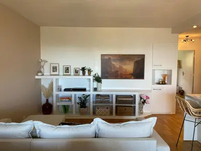 a living room with a couch and a table at WeHost- CORNICHE Soleil Couchant 2 chambres 4pers,Parking,Piscine in Nice