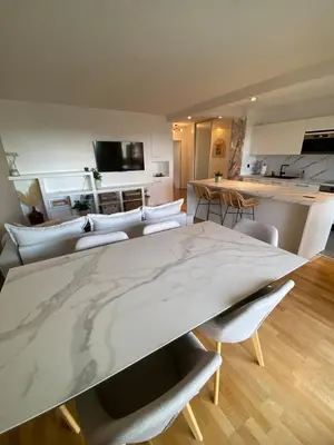 a kitchen with white cabinets and a large counter at WeHost- CORNICHE Soleil Couchant 2 chambres 4pers,Parking,Piscine in Nice