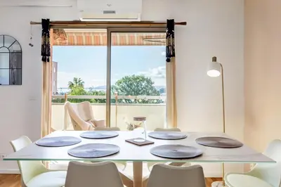 a balcony with a table and chairs on a balcony at WeHost- CORNICHE Soleil Couchant 2 chambres 4pers,Parking,Piscine in Nice