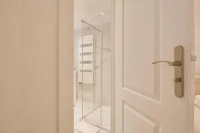 a glass door in a bathroom with a towel rack at Magnifique appartement rénové au port de Nice in Nice