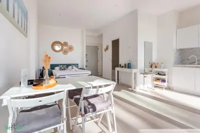 a white bedroom with a bed and a balcony at WeHost Promenade - garden retreat for 2 pers 1bed in Nice