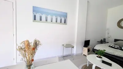 a white kitchen with white cabinets and a microwave at WeHost Promenade - garden retreat for 2 pers 1bed in Nice