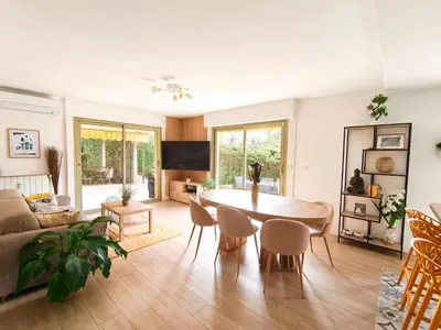 a living room with a table and a couch at Havre de paix à Nice Cimiez -T4 en rez-de-jardin in Nice