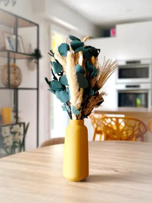 a yellow vase with a plant in it on a table at Havre de paix à Nice Cimiez -T4 en rez-de-jardin in Nice