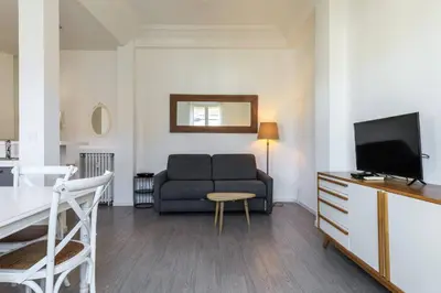 a living room with a couch and a television at Charmant 2 pieces dans le carre d or in Nice