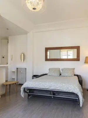 a white bedroom with a bed and a mirror at Charmant 2 pieces dans le carre d or in Nice