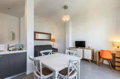 a kitchen and a living room with a table and chairs at Charmant 2 pieces dans le carre d or in Nice