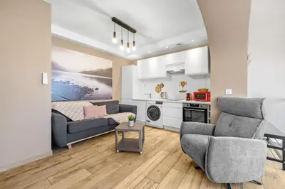 a living room with two chairs and a couch at Appartement Charme de la Promenade vue mer - Welkeys in Nice