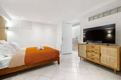 a bedroom with a bed and a flat screen tv at Appartement Charme de la Promenade vue mer - Welkeys in Nice