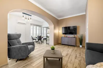 a living room with a couch and chairs and a table at Appartement Charme de la Promenade vue mer - Welkeys in Nice