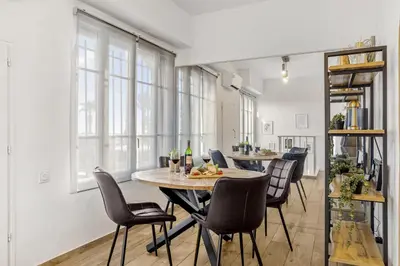 a dining room with a table and chairs at Appartement Charme de la Promenade vue mer - Welkeys in Nice