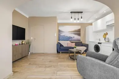 a living room with a couch and a table at Appartement Charme de la Promenade vue mer - Welkeys in Nice