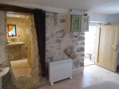a bathroom with a stone wall and a sink at La grotte in Aspremont
