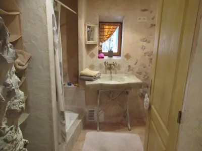 a bathroom with a sink and a shower with a window at La grotte in Aspremont