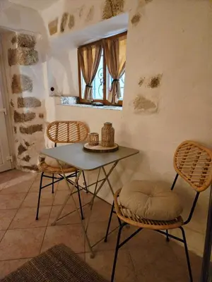 a table and chairs in a room with a window at La grotte in Aspremont