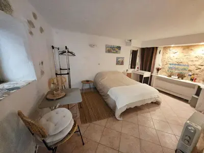 a bedroom with a bed and a table and chairs at La grotte in Aspremont