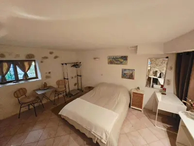 a bedroom with a bed and a table and chairs at La grotte in Aspremont