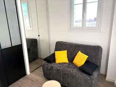 a living room with a couch with two yellow pillows at Hyper centre massena in Nice