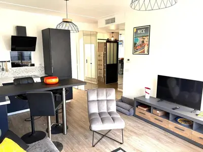 a living room with a table and chairs and a tv at Hyper centre massena in Nice