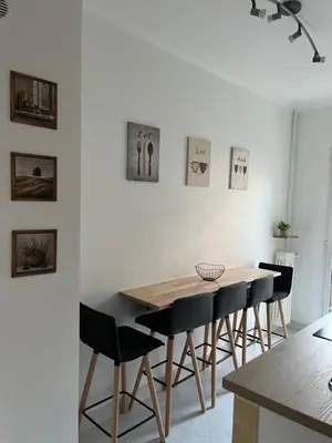 a dining room with a wooden table and chairs at De Gaulle 2 pièces Сentral Appartement in Cagnes-sur-Mer