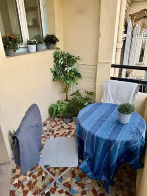 a table and a chair on a balcony with a table at Charmant studio avec terrasse pour amoureux in Nice