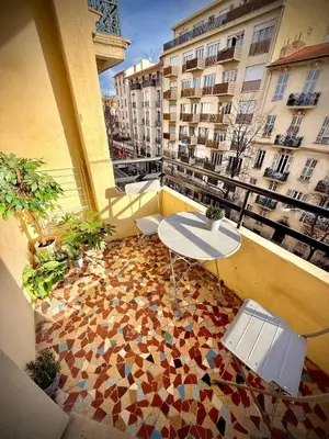 a balcony with a table and chairs on a building at Charmant studio avec terrasse pour amoureux in Nice