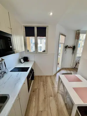 a kitchen with white cabinets and a counter top at Charmant studio avec terrasse pour amoureux in Nice