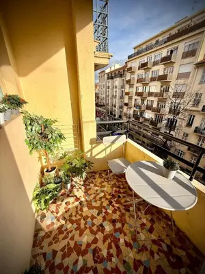 a balcony with a table and plants on a building at Charmant studio avec terrasse pour amoureux in Nice