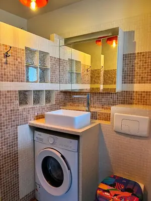 a bathroom with a washing machine and a sink at Holidays 80 in Saint-Laurent-du-Var