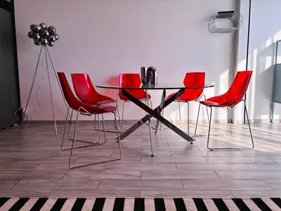a table and red chairs in a room at Holidays 80 in Saint-Laurent-du-Var