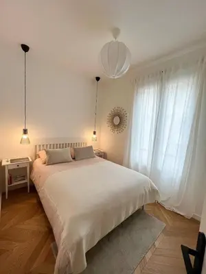 a bedroom with a large white bed and two windows at Nice Boheme in Nice
