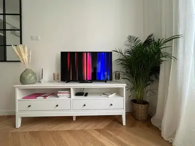 a white entertainment center with a tv on top of it at Nice Boheme in Nice