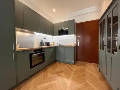 a kitchen with green cabinets and a wooden floor at Nice Boheme in Nice