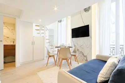 a living room with a bed and a table and chairs at Duplex moderne climatisé Carré d'or in Nice