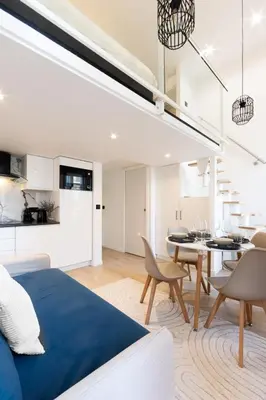 a living room and dining room with a bed and a dining table at Duplex moderne climatisé Carré d'or in Nice