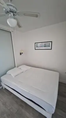 a white bed in a room with a ceiling fan at Nice Mont Boron proche du Port in Nice