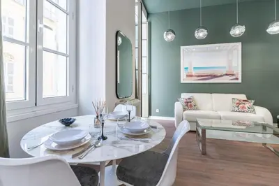 a living room with a table and a couch at La Perle de Masséna in Nice