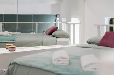 a reflection of a bedroom with two beds and a mirror at La Perle de Masséna in Nice