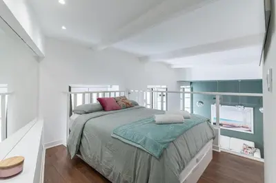 a bedroom with a bed in a white room at La Perle de Masséna in Nice