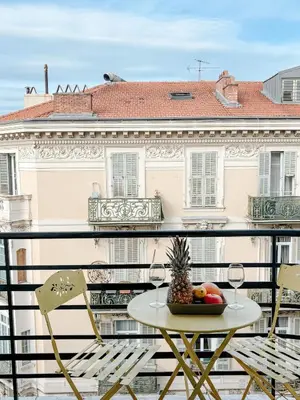 a table with a pineapple and two chairs on a balcony at Elegant Apartment with Balcony, Central Nice in Nice