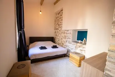a bedroom with a bed and a stone wall at Dolce Vita Clemenceau - Nice City Center 4 People in Nice