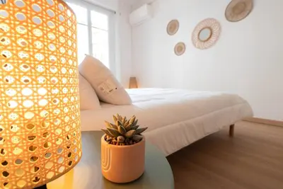 a bedroom with a bed and a potted plant on a table at Bright apartment Nice harbour in Nice