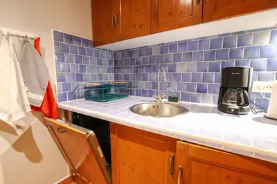 a kitchen counter with a sink and blue tiles at ROCHE-Rock in the heart of the Old Town in Villefranche-sur-Mer