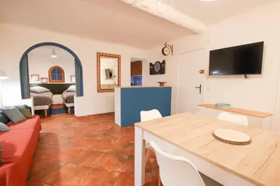 a living room with a red couch and a table at ROCHE-Rock in the heart of the Old Town in Villefranche-sur-Mer