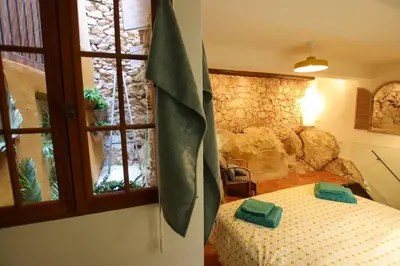 a bedroom with a bed and a stone wall at ROCHE-Rock in the heart of the Old Town in Villefranche-sur-Mer