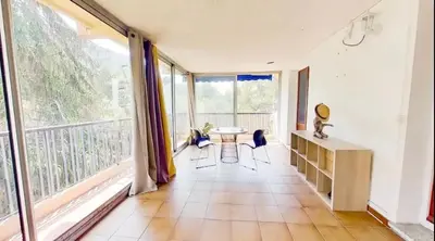 a room with a table and chairs and a large window at Nice collines in La Trinité