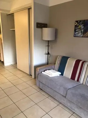 a living room with a couch and a lamp at Héliotel Marine in Saint-Laurent-du-Var