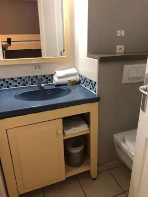 a bathroom with a sink and a toilet at Héliotel Marine in Saint-Laurent-du-Var
