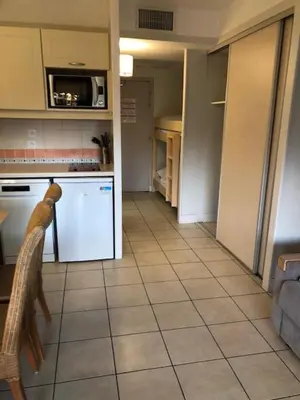a kitchen with white appliances and a tiled floor at Héliotel Marine in Saint-Laurent-du-Var